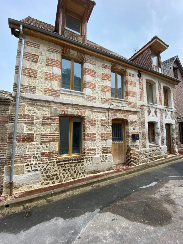 Façade de maison ancienne en pierre et brique rénovée avec menuiseries bois par MVT RENO